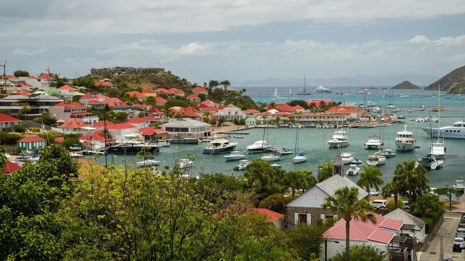Gustavia harbour and its red roofs seen from the hillside, yachts at anchor in the bay