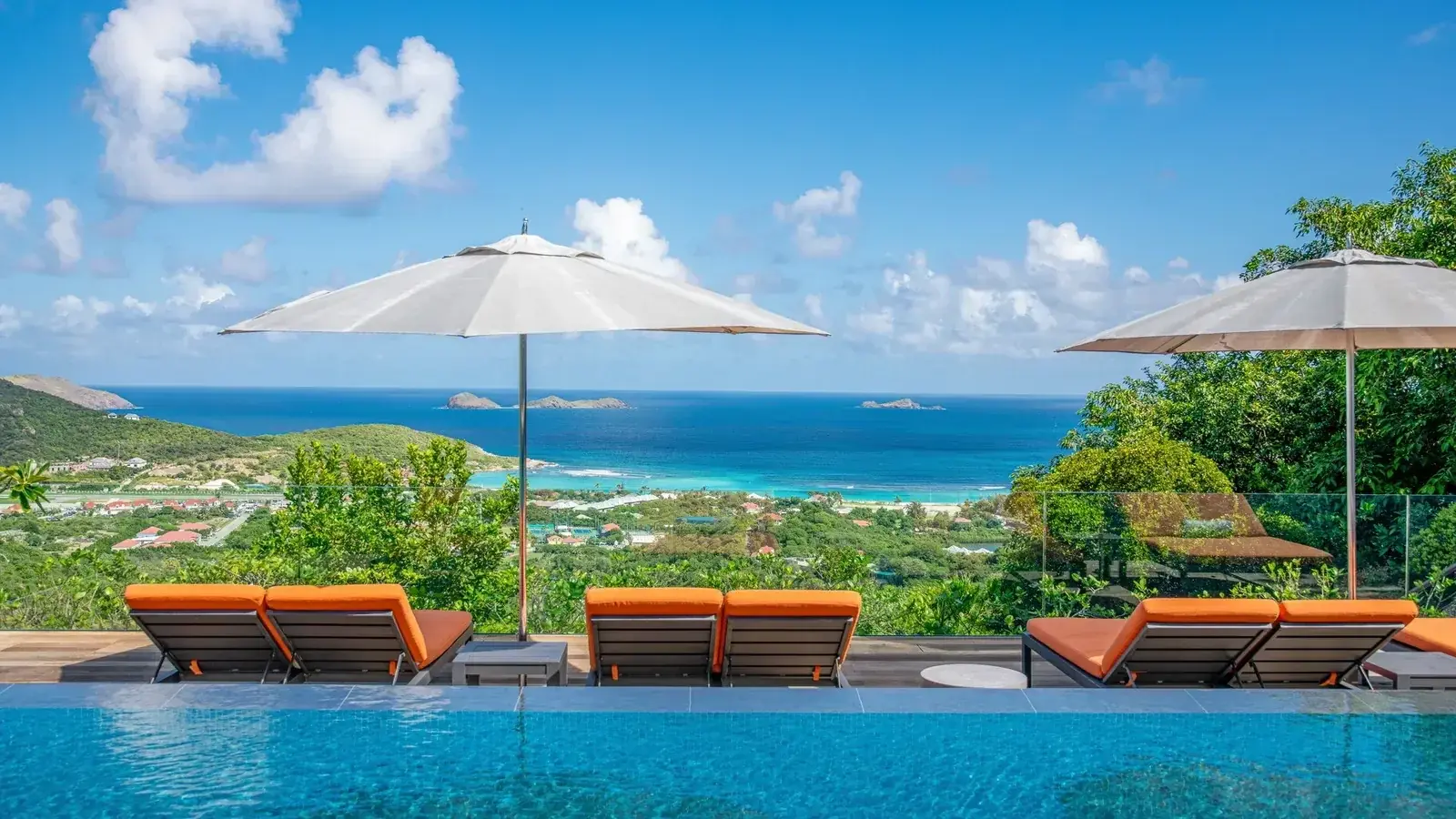 Sun loungers and umbrellas on a terrace above the bay of St Jean
