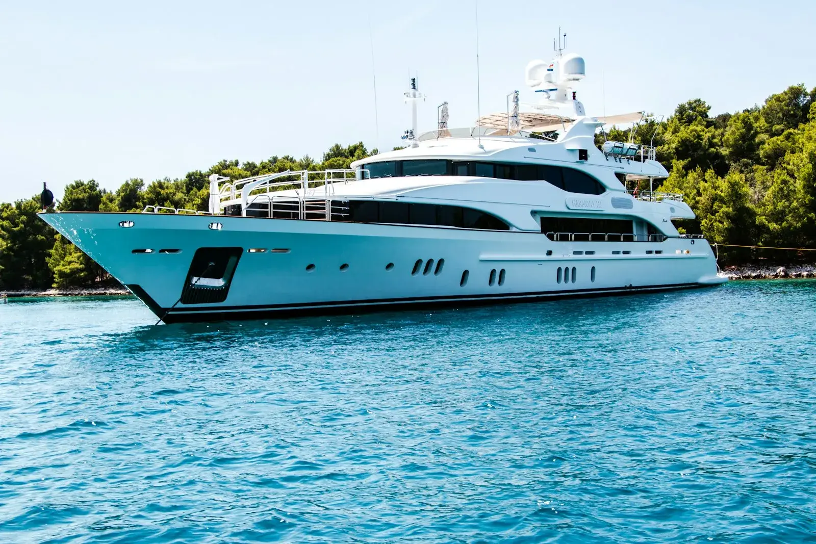 A large white motor yacht anchored in the calm blue water off St Barts