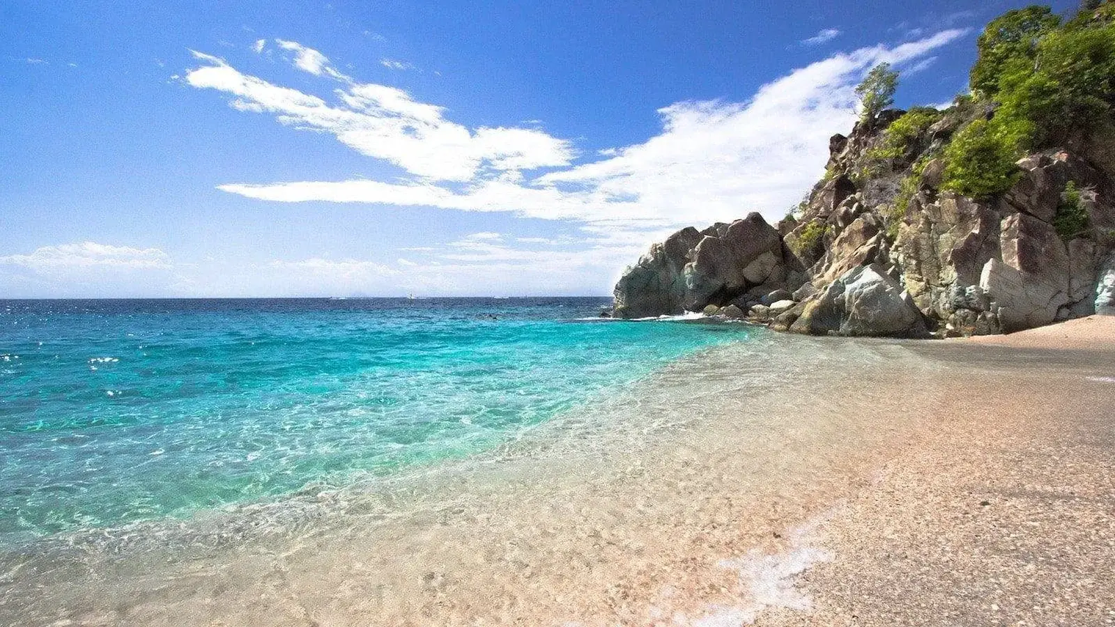Shell Beach in Gustavia, its coarse shell sand and the rocks at the end of the cove